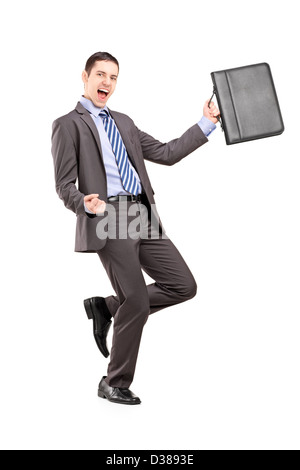 Full length portrait of a happy young businessman holding a briefcase and gesturing happiness isolated on white background Stock Photo