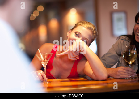 Woman ordering another drink at bar Stock Photo