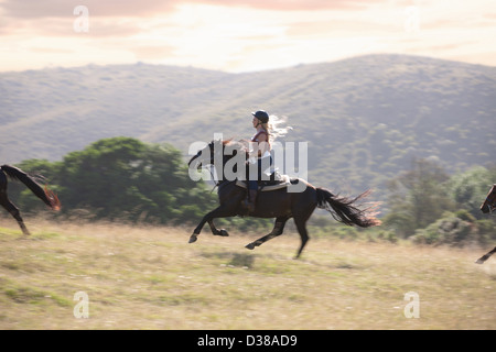 Woman riding horse in rural landscape Stock Photo