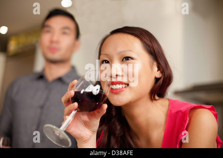 Woman drinking wine in kitchen Stock Photo