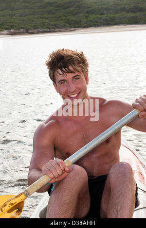 Smiling man rowing kayak in lake Stock Photo