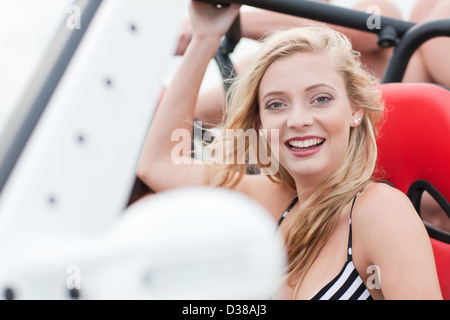 Smiling woman riding in jeep Stock Photo