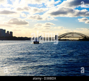 Sydney hydrofoil against a silhouette of the Sydney Harbor Bridge and the Sydney Opera House. Stock Photo