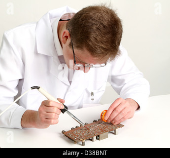 working electronics repairing board using soldering pen on a light background Stock Photo