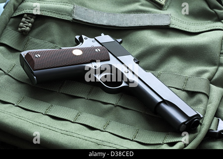 Legendary semi-automatic M1911 Mark IV Series 80 .45 caliber pistol on a green background Stock Photo