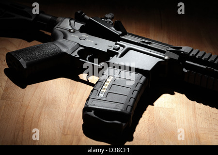 Modern custom AR-15 (M4A1) carbine on a wooden surface. Studio shot ...