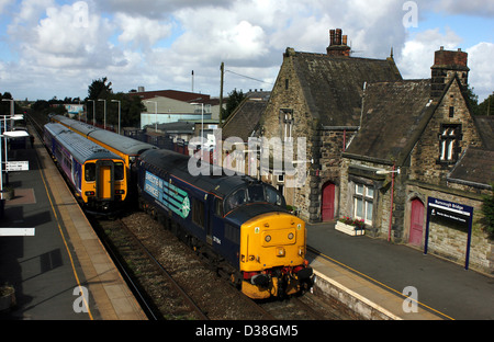 DRS diesel locomotive 37 194 at the head of a track testing train passes through the rural village station at Burscough Bridge in West Lancashire. Stock Photo