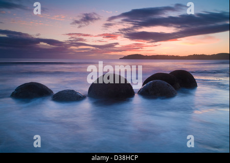 Waves washing over rocks on beach Stock Photo