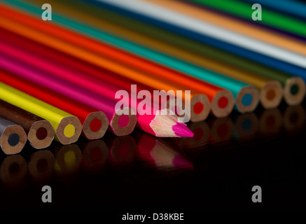 Coloured pencils lined up on a table Stock Photo