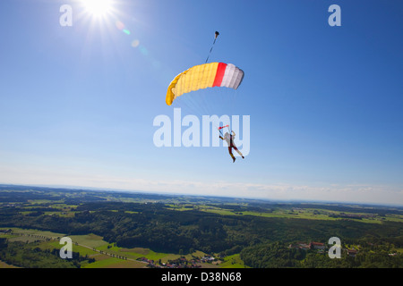 Man parachuting over rural landscape Stock Photo