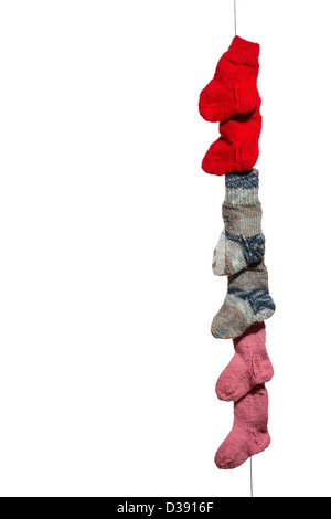 Blue, red, pink and white babysocks on a line in front of a white background Stock Photo