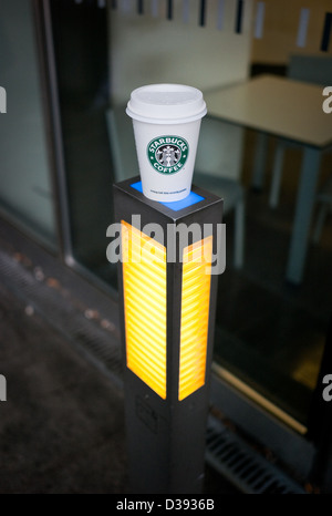 Berlin, Germany, a Starbucks paper cups standing on a lamp Stock Photo