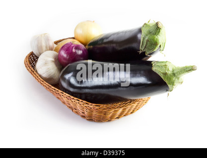 basket with eggplants, onions and garlic isolated on white background Stock Photo