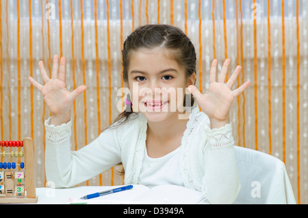 A schoolgirl at her desk with abacus Stock Photo