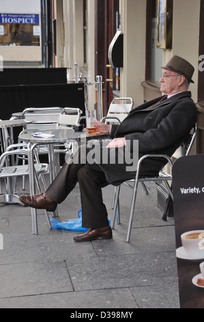 Senior citizen drinking alcohol in pavement cafe bar in Glasgow, Scotland, UK, Europe. Stock Photo