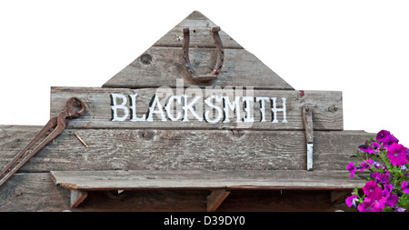 Old sign with word blacksmith on rustic wood boards and rusty old vintage tools. Stock Photo