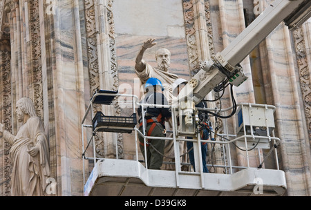 Workers restoring artwork sculpture statue stonework on facade of Milan Cathedral Milano Lombardy Italy Europe Stock Photo