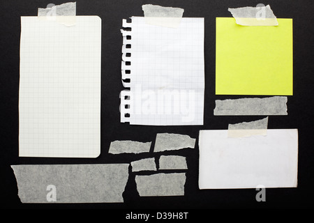 Torn paper scraps set and tape on black background Stock Photo