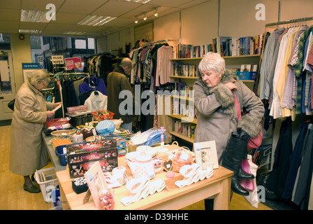 Customers browsing items on display in a charity shop, Godalming, Surrey, UK. Stock Photo