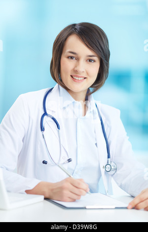 Vertical portrait of a young female doctor at her workplace Stock Photo