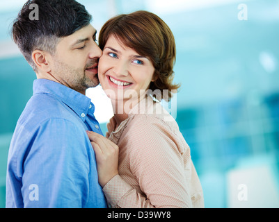 Portrait of happy middle aged woman enjoying her husband kiss Stock Photo