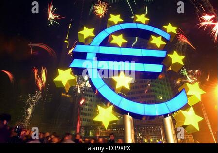 (dpa) - Firecrackers rise into the sky behind the giant Euro sculpture that stands in front of the European Central Bank (ECB) in Frankfurt, 1.1.2002. January 1st, 2002 marked the official date for the launch of the Euro as common currency for 300 million citizens in twelve European states: Belgium, Stock Photo