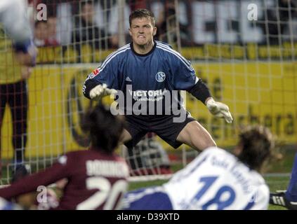 (dpa) - Schalke's goalkeeper Frank Rost watches his teammate Niels Oude Kamphuis (front R) fight for the ball with Kaiserslautern's Portuguese midfielder Jose Manuel Dominguez (front L) during the Bundesliga soccer game of FC Schalke 04 against FC Kaiserslautern in Kaiserslautern, Germany, 13 Decemb Stock Photo