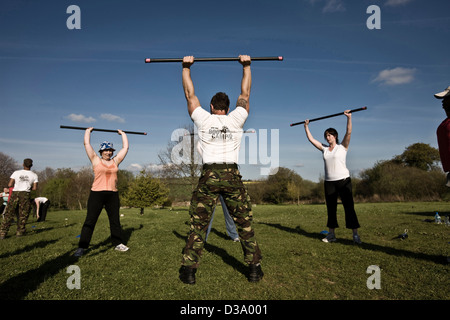 Fitness instructor leading weight lifting class at luxury boot camp, Kingston House, Totness, Devon Stock Photo
