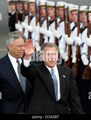 (dpa) - George W. Bush, President of the United States, waves as he passes the guard of honor accompanied by US Foreign Minister Colin Powell (L) upon their arrival at Berlin airport, 22 May 2002. Bush is on a one-week visit to Europe, Germany being his first stop. His 24-hour stay in Berlin provoke Stock Photo
