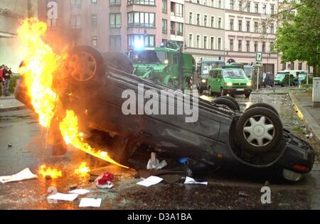 (dpa) - A turned over car is burning on the verge of Labour Day demonstrations in Berlin, 1 May 2002  As in the past years, the riots caused heavy damages as cars, barricades, public phones and windows were demolished. Police used water cannons to banish the rioters. Stock Photo