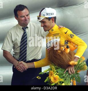 (dpa) - The five time Tour De France winner Bernard Hinault (L) shakes hands with the Spanish cyclist Igor Gonzalez de Galdeano of the Once-Ersoki team who wears the yellow jersey during the 9th stage of the Tour De France in Pont-Scorff, 15 July 2002. Stock Photo