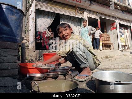 (dpa) - A girl works as a dishwasher in the slums of Kathmandu in Nepal, 24 November 2000. Unicef tries to help those children to a better future with school education. Stock Photo