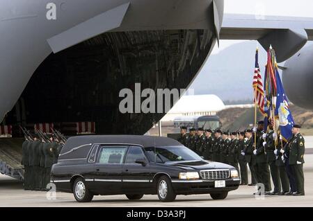 (dpa files) - A hearse stands in front of a US aircraft at Ramstein Air Base, Germany, 5 March 2002, while a US Army honor guard pays tribute to the seven US American soldiers killed in a missile attack in Afghanistan the day before. The coffins containing the remains of the soldiers were flown to D Stock Photo