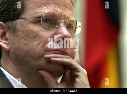 (dpa) - Guido Westerwelle, German chairman of the Liberal party (FDP), rests his head in his hand in front of the German national flag during an election campaign of his party in the former Bundestag in Bonn, Germany, 7 July 2002.