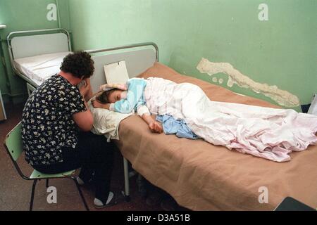 (dpa files) - A dispaired mother sits at the bed of her daughter, who is infected with the HIV virus, in the Municipal Hospital in Constanta, Romania, 2 June 2001. The hospital is a home for children suffering from Aids, and doctors looks after altogether 920 infected children in the district of Con Stock Photo