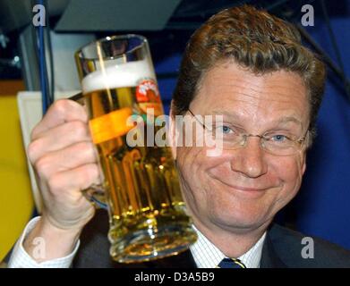 (dpa) - Guido Westerwelle, Chairman of the German liberal party FDP, enjoys a beer after a speech at a party meeting in Passau, Germany, 13 February 2002. Westerwelle has been nominated as the FDP's chancellor candidate in this year's general elections on 22 September, which makes him the first chan