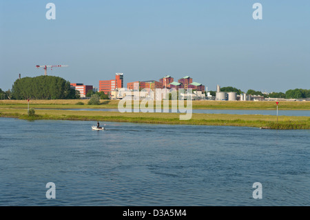 man in motorboat on river with modern office buildings in the background Stock Photo