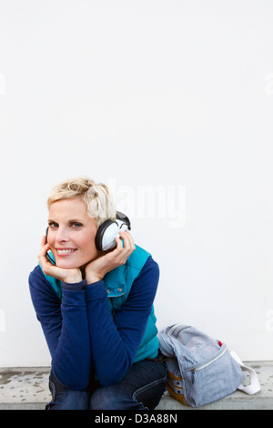 Smiling woman listening to headphones Stock Photo