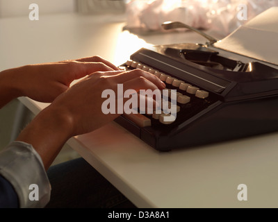 Close up of woman using typewriter Stock Photo