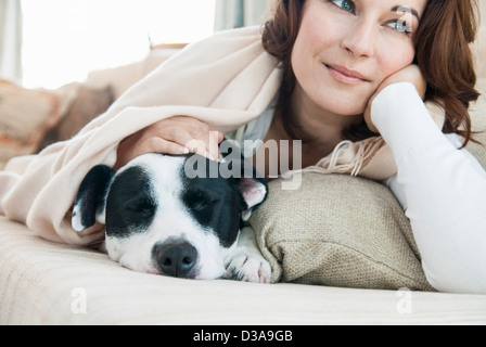 Woman relaxing on sofa with dog Stock Photo