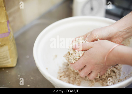 Woman shaping dough in kitchen Stock Photo