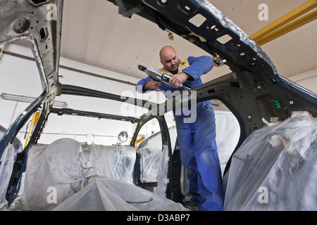 Mechanic working on car in garage Stock Photo