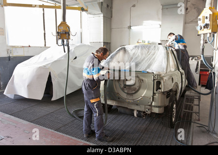 Mechanics working on car in garage Stock Photo