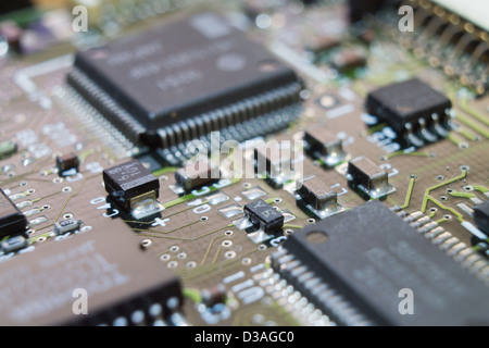 Microchips surrounded by other elements on a circuit board Stock Photo