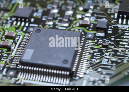 Microchips surrounded by other elements on a circuit board Stock Photo