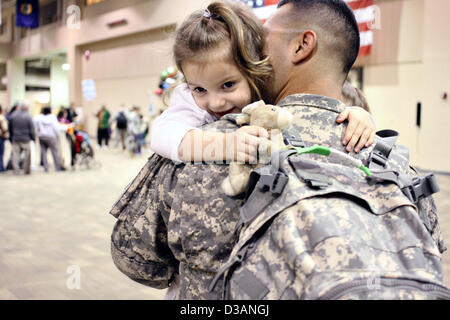 US Army Spc. Jose Cisneros hugs his daughter Rosalyn after returning from a nine month deployment to Kuwait February 14, 2013 at Fort Benning, GA. More than 300 soldiers were reunited with family and friends just in time to celebrate Valentine Day. Stock Photo