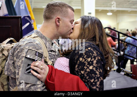 US Army Sgt. Corbett Futral kisses his wife Jessica after returning from a nine month deployment to Kuwait February 14, 2013 at Fort Benning, GA. More than 300 soldiers were reunited with family and friends just in time to celebrate Valentine Day. Stock Photo