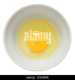 An egg broken into a bowl and seen from above over a white background. Stock Photo