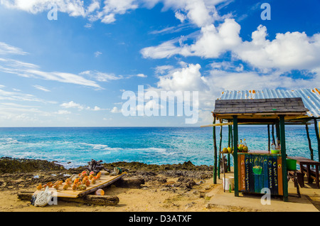Outdoor bar with drinks in coconuts and souvenirs for sale in San Andres, Colombia Stock Photo