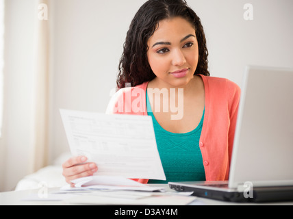 Hispanic woman working on laptop Stock Photo